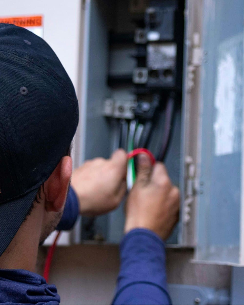 Ampworks electrician wiring a residential breaker panel